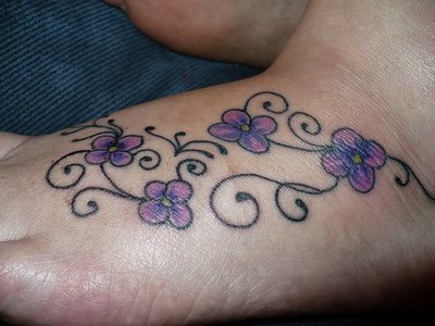 A picture of a butterfly and flowers tattooed on the side of the foot.